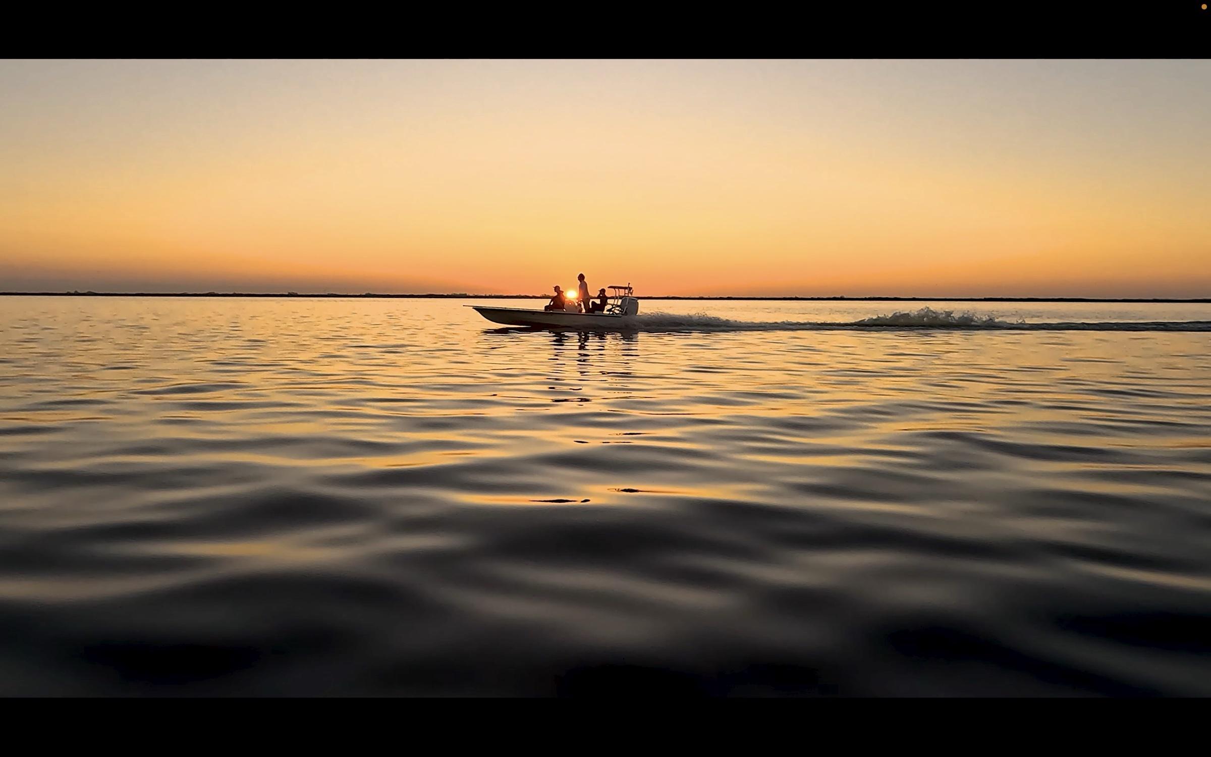 Skiff cruising at sunset across Pine Island Sound