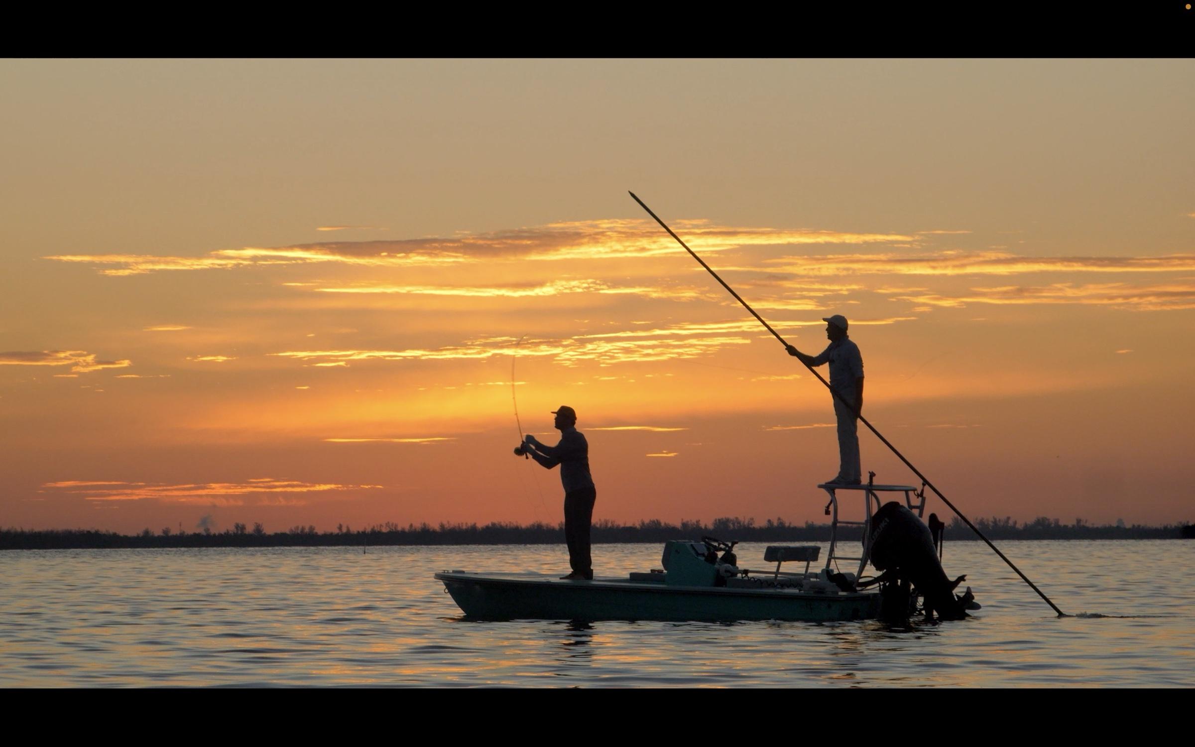 Fly angler casting at sunset off the bow of a flats skiff in Southwest Florida